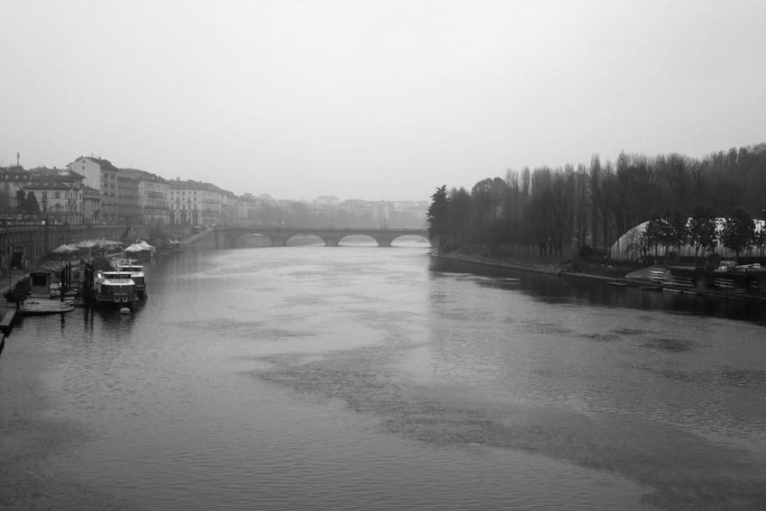 Río urbano con puentes y edificios en un día gris