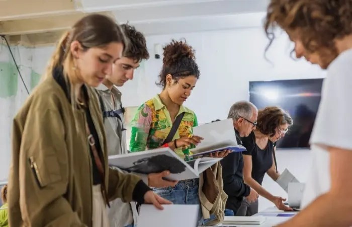Grupo de gente en la exposición "Fotolibros e identidad: ventanas a la diversidad cultural y social" en el Festival Revela't 2024.
